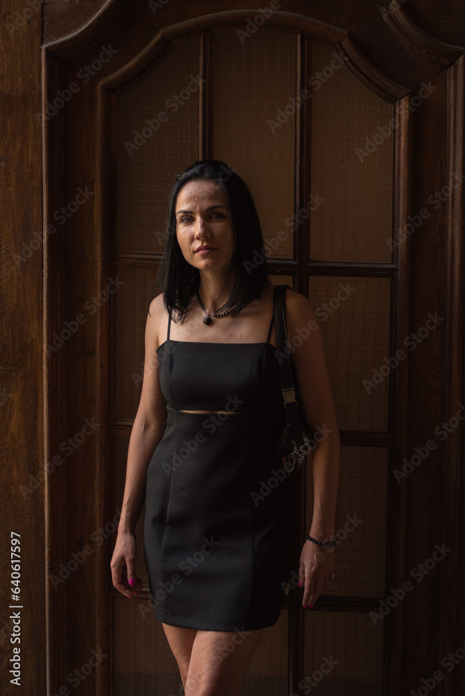 Fototapeta premium Beautiful young black hair woman walking on the summer street of old town in summer