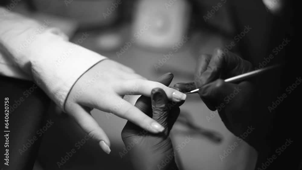 Professsional nails care in beauty salon.Manicurist paints fingernails. Process of making nail