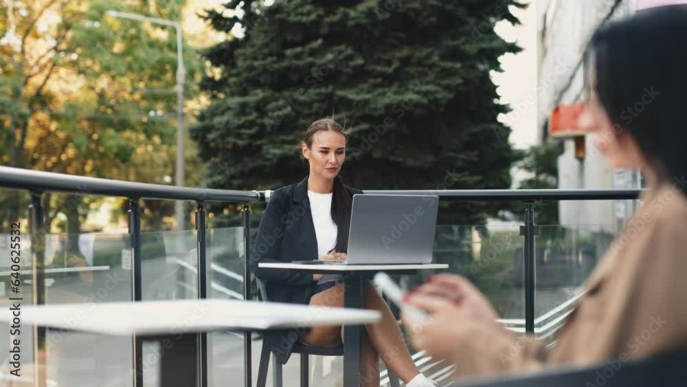Young woman focusing on her work, looking at laptop screen, nomad remote workplace, sitting on rooftop outdoors with relaxing view with bottle of water. Young woman focusing on her work, looking at laptop screen, nomad remote workplace, sitting on rooftop outdoors with relaxing view with bottle of water.