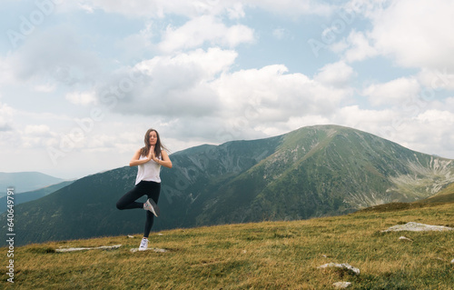 Meditation and gymnastics in a beautiful mountain landscape, at high altitude. A beautiful woman practices Yoga exercises.