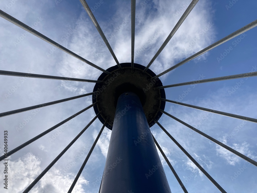 View of tower with spokes around it against the sky 