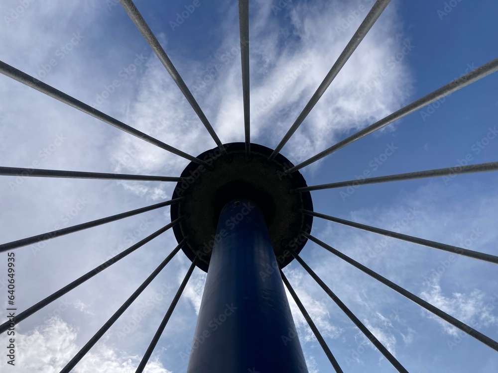 View of tower with spokes around it against the sky 
