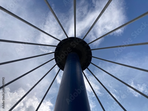 View of tower with spokes around it against the sky 