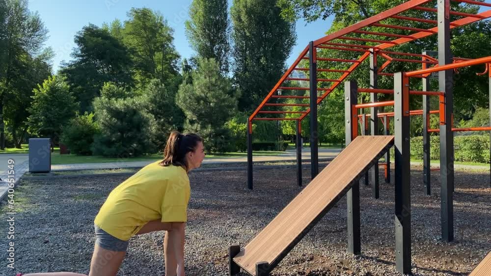 Multiracial young woman doing dynamic exercise routine at outdoor street workout park in morning sunlight. Female sportsperson training, improving agility, determination by using outdoor gym equipment Multiracial young woman doing dynamic exercise routine at outdoor street workout park in morning sunlight. Female sportsperson training, improving agility, determination by using outdoor gym equipment