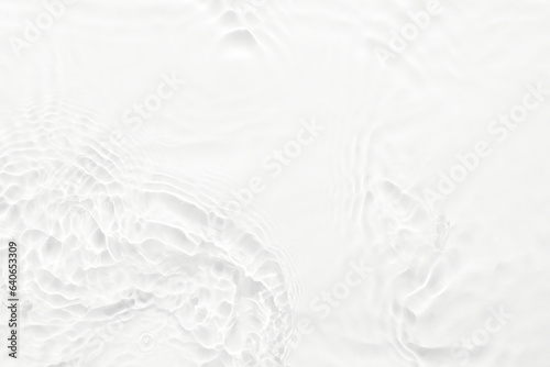Water white surface abstract background. Waves and ripples texture of cosmetic aqua moisturizer with bubbles.