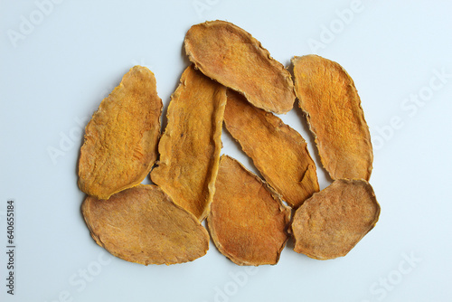 Sliced and dried rhizome of Curcuma zanthorrhiza, or temulawak. Isolated on white background. Flat lay or top view photo