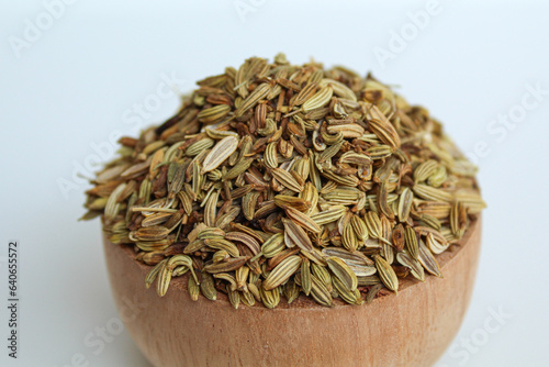 Dried Aniseed, or Pimpinella Anisum seed, or Adas Manis, inside wooden bowl. Isolated on black background photo