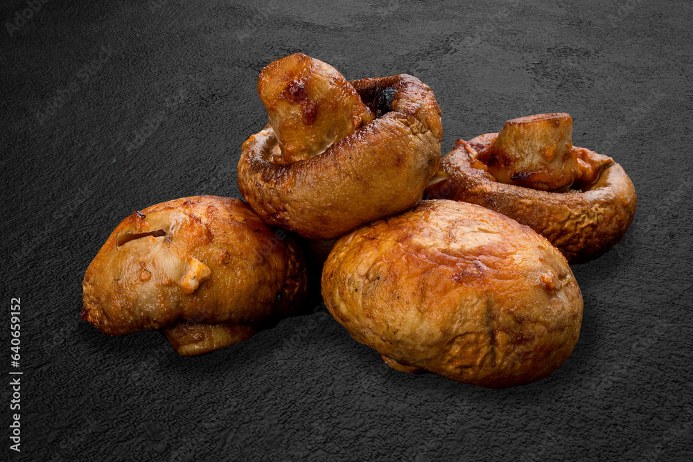 Grilled mushrooms on a background of dark stone. BBQ menu Grilled mushrooms on a background of dark stone. BBQ menu
