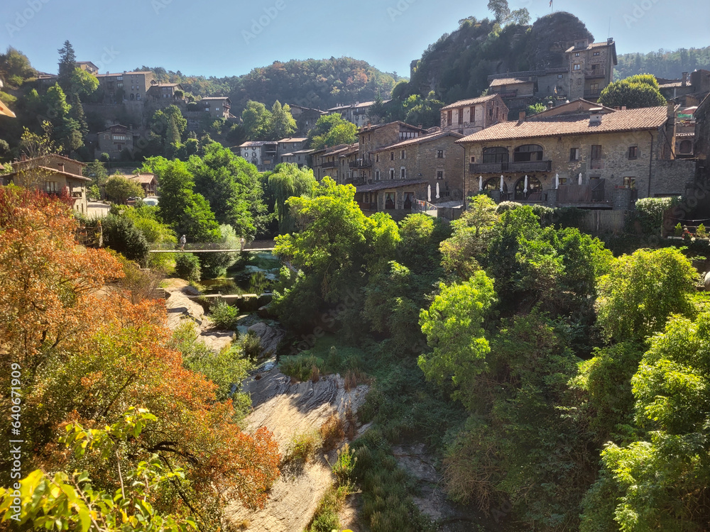 View of the medieval village with its suspension bridge over the river in the Osona region, Catalonia.