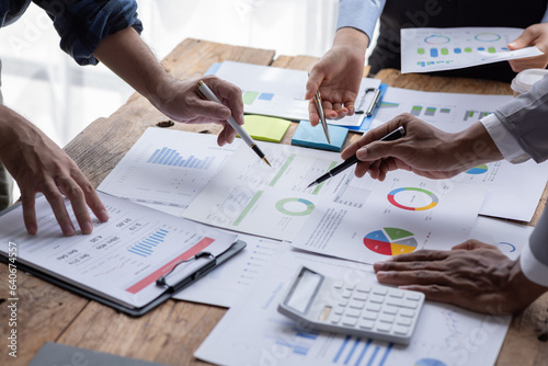 Financial analysts analyze business financial reports on a digital tablet planning investment project during a discussion at a meeting of corporate showing the results of their successful teamwork.