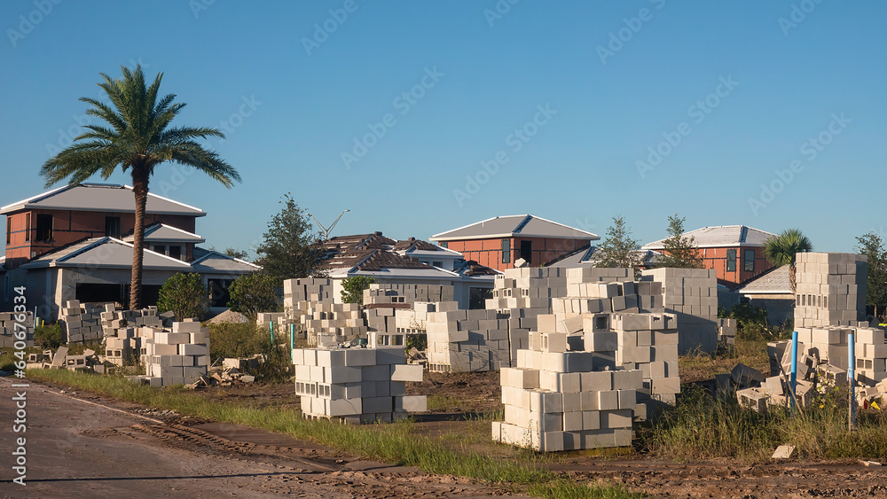 Stacks of concrete blocks on future construction site of a single-family house in a suburban development on a sunny morning in southwest Florida