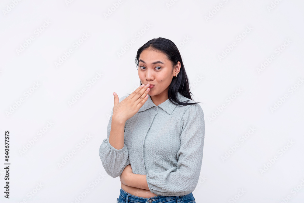 A young carefree asian woman making an oops gesture. Reacting to the latest gossip. Isolated on a white background. A young carefree asian woman making an oops gesture. Reacting to the latest gossip. Isolated on a white background.