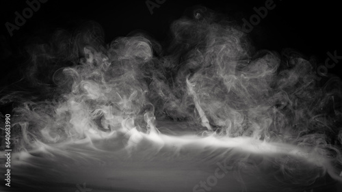 Smoke, fog or steam on black background flowing or rolling from center to edges