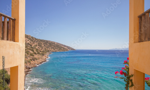 View of the turquoise mediterranean sea at the island of Crete  Greece  with traditional buildings and flowers  near Agios Nikolaos