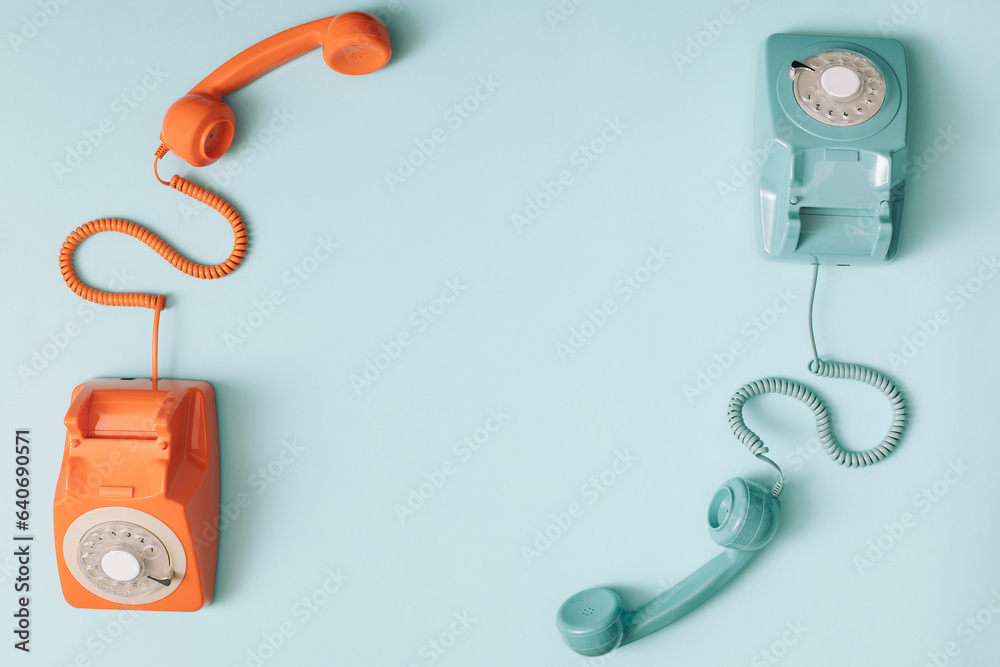 Two phones with the headset up. Retro colour telephones. Copy space. Two phones with the headset up. Retro colour telephones. Copy space.