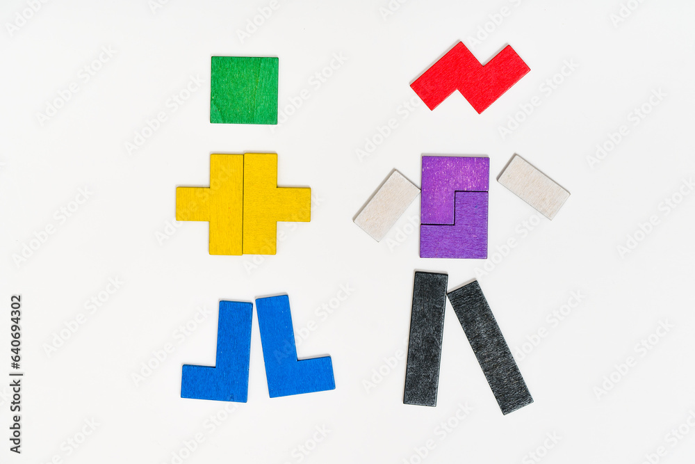 Fototapeta premium Abstract boy and girl collected from puzzle. Kids toys. Colorful educational wooden toys on white background. Montessori Games. Child Development.