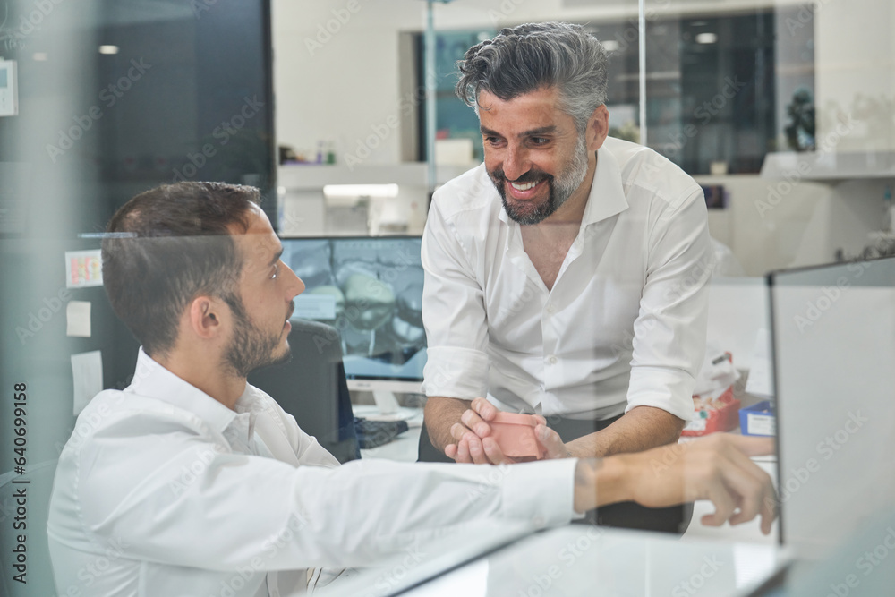 Joyful men discussing project in office Joyful men discussing project in office