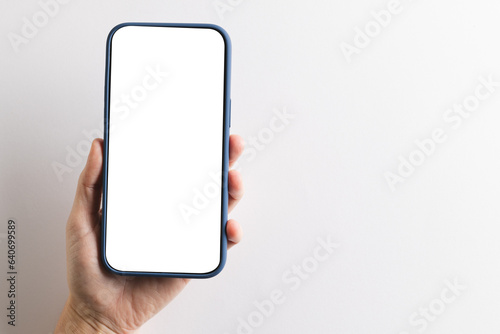 Hand of caucasian woman holding smartphone with blank screen and copy space on white background