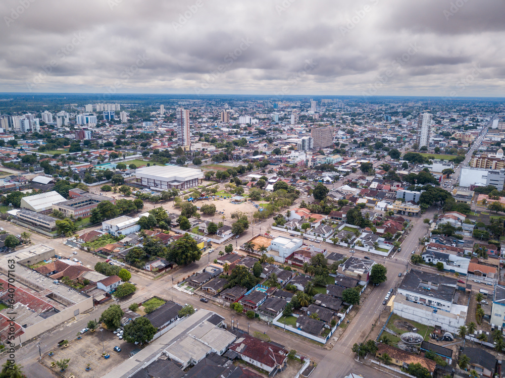 Fototapeta premium Beautiful aerial drone view of Porto Velho city center skyline, streets, squares. Amazon rainforest in the background on cloudy summer day. Rondonia state, Brazil.