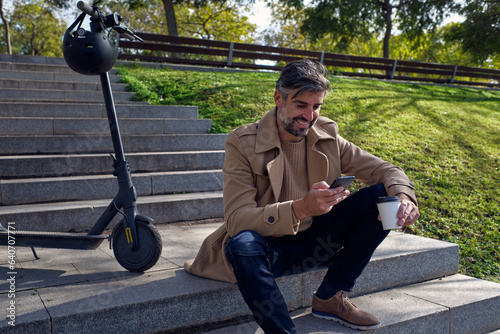 Photography Unshaven man using smartphone in park