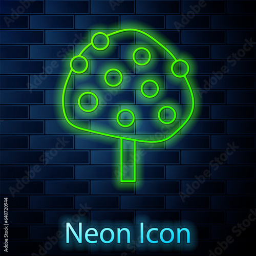 Glowing neon line Orange tree with fruits icon isolated on brick wall background. Vector