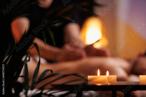 The hands of the male masseur are actively rubbing the visitors back, a therapeutic massage for tired muscles. Point massage in the spa center. Body therapy for a healthy lifestyle.