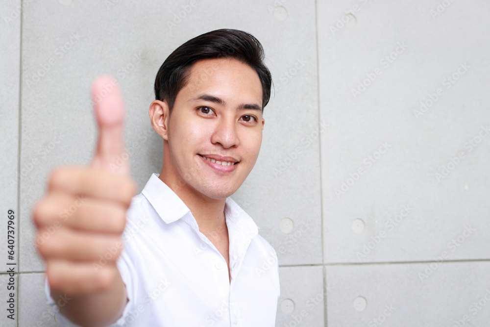 Portrait of an Asian man working in an office smiling and giving a thumbs up. Businessman concept. copy space Portrait of an Asian man working in an office smiling and giving a thumbs up. Businessman concept. copy space