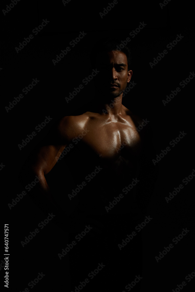 Fototapeta premium Topless, muscle and portrait man in dark background for fitness inspiration, beauty aesthetic or strong body. Shadow aesthetic, topless male model or body builder in creative studio with art lighting