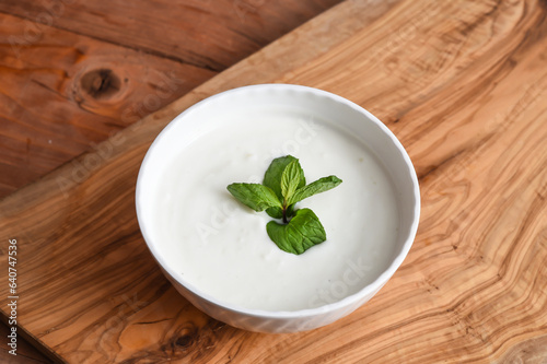 Cucumber And Mint yogurt raita served in dish isolated on wooden table top view middle eastern appetizers food