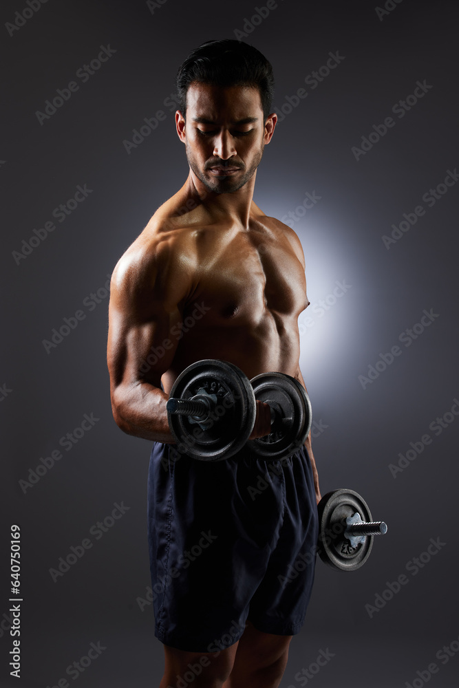 Muscle, strong and studio man with dumbbell challenge results, arm workout development and body fitness progress. Dark shadow, gym equipment and sports athlete with training focus on grey background Muscle, strong and studio man with dumbbell challenge results, arm workout development and body fitness progress. Dark shadow, gym equipment and sports athlete with training focus on grey background