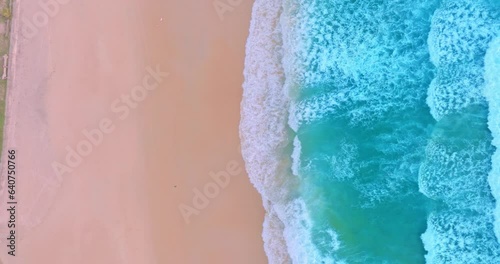 .aerial top view White foam waves in the bright green sea lapping on the white sandy beach..Wave after wave swept towards the shore. .white bubble waves, and clear sand landscape. Paradise beach..