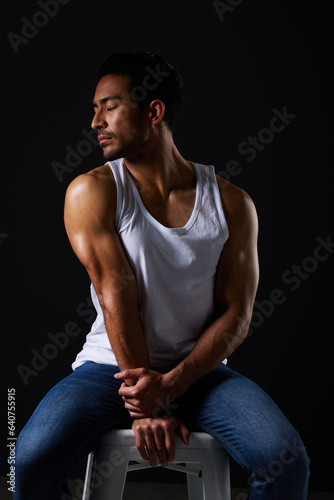 Relax, muscle and sexy man on chair in studio with fitness inspiration, beauty aesthetic and sensual fashion. Erotic art, sexual body and male model on black background, thinking with dark lighting.