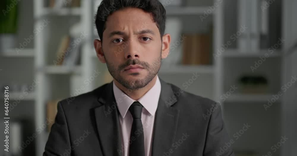 Portrait of sad businessman sitting at modern office in front of camera. Portrait of sad businessman sitting at modern office in front of camera.