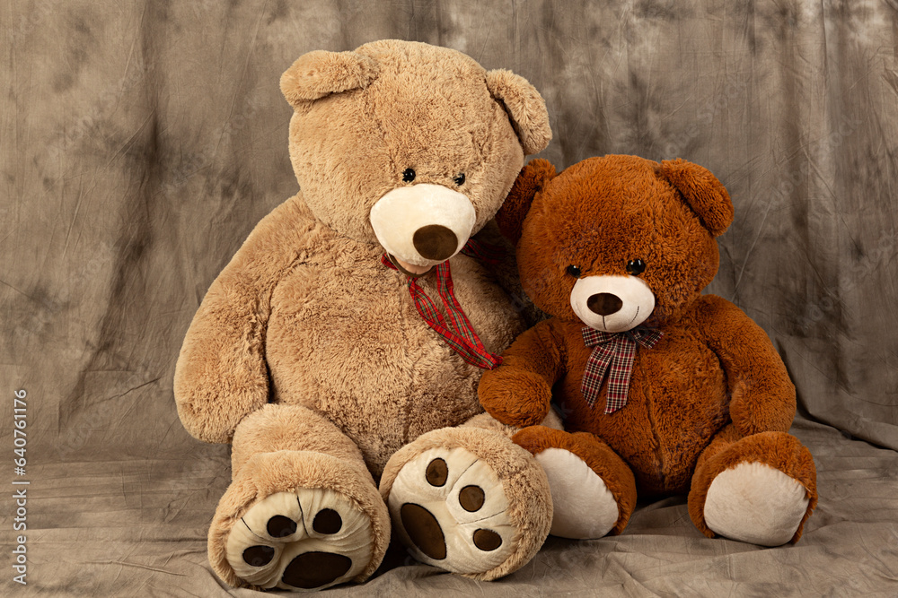 Dos ositos de peluche sentados sobre fondo marrón. Dos ositos de peluche sentados sobre fondo marrón.