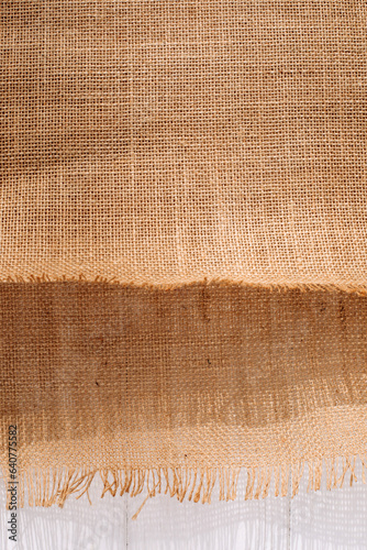 Textured background for design. Brown burlap fabric on a white background. Top view