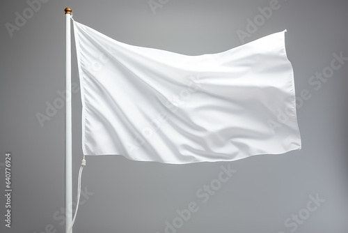 Closeup of a white flag waving on a flagpole against a gray background isolated  photo