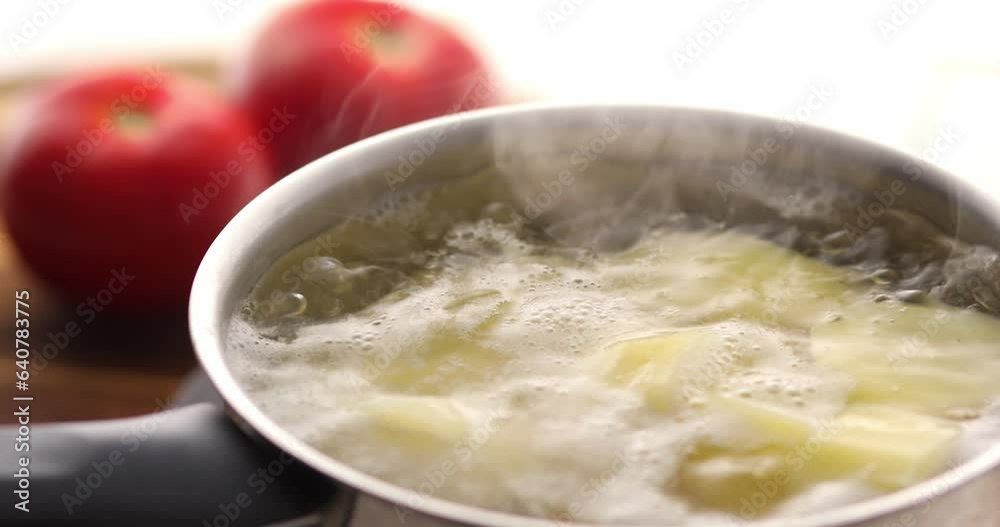 Potatoes in a saucepan of boiling water are mixed with a spatula. Cooking vegetables. The process of food preparation. Potatoes in a saucepan of boiling water are mixed with a spatula. Cooking vegetables. The process of food preparation.