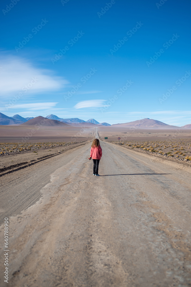 woman walking in the middle of the road to El Tatio woman walking in the middle of the road to El Tatio