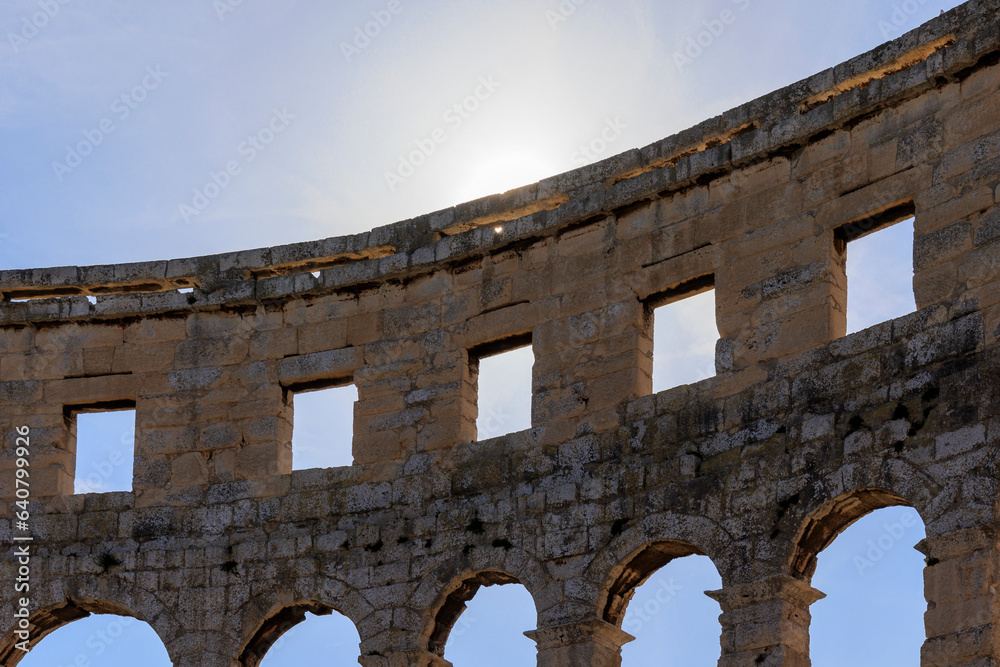 Obraz premium The ruins of the Roman arena in the Croatian city of Pula under a blue sky on a sunny day
