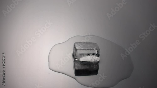 Melting ice cube on black, time lapse