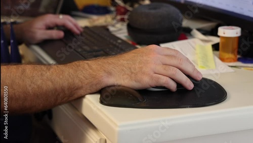 Camera is focusing on a mouse and the hand using the mouse while the person is working.