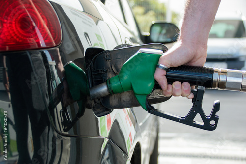 Close-up of the hand of a Caucasian man refueling his car with unleaded fuel.