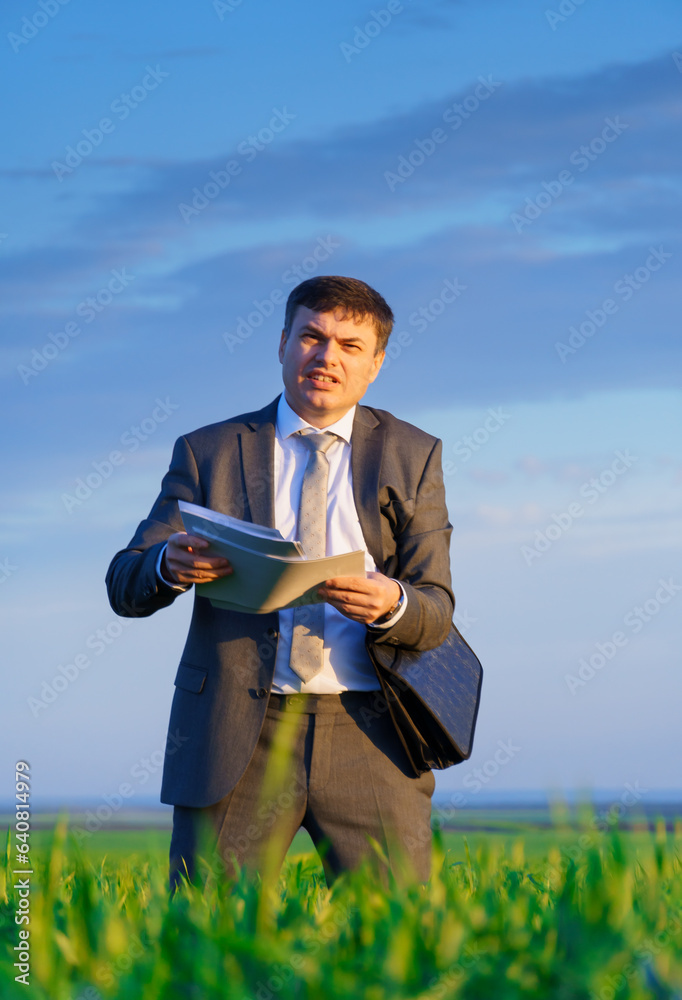 a businessman poses on a green grass field, concept of leisure or freelancing a businessman poses on a green grass field, concept of leisure or freelancing
