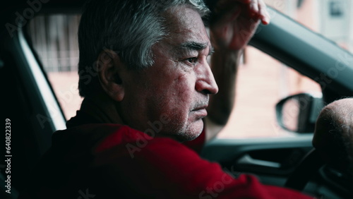 Fotografie Elderly man suffering emotional pain inside car, parked in street