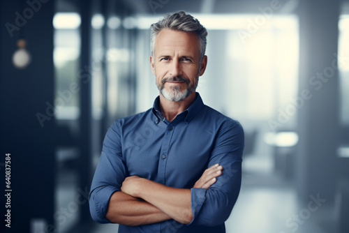 Middle aged business man standing with arms crossed in an office