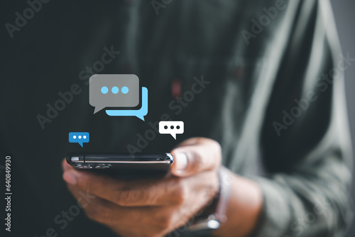 Man smartphone becomes portal for live chat engagement, representing social networking and chatting concepts. Chat box icons highlight interplay of communication and modern technology.