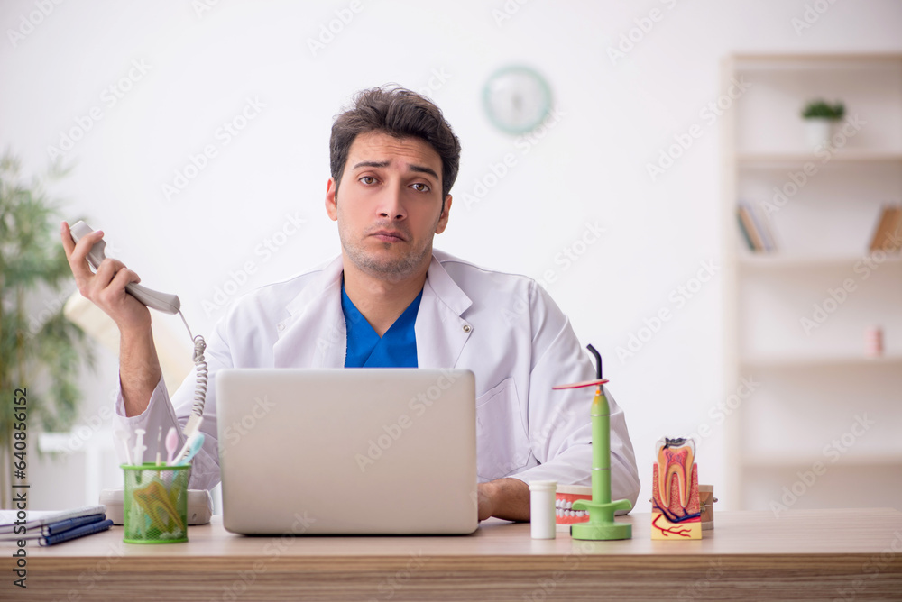 Young male dentist working in the clinic Young male dentist working in the clinic