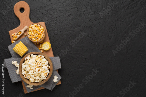 Prepared popcorn with ingredients on concrete background, top view