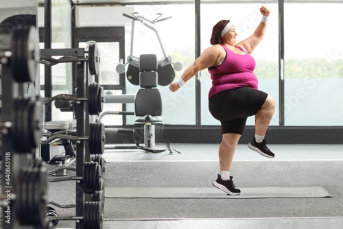 Young overweight woman exercising in a gym