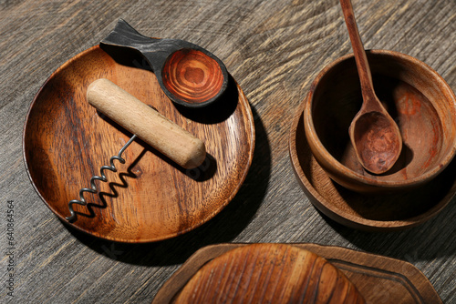 Bowls, plate and corkscrew on wooden background